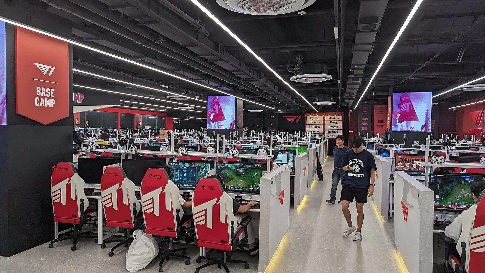 Rows of gaming PCs and red-and-white chairs inside T1 Base Camp in Seoul