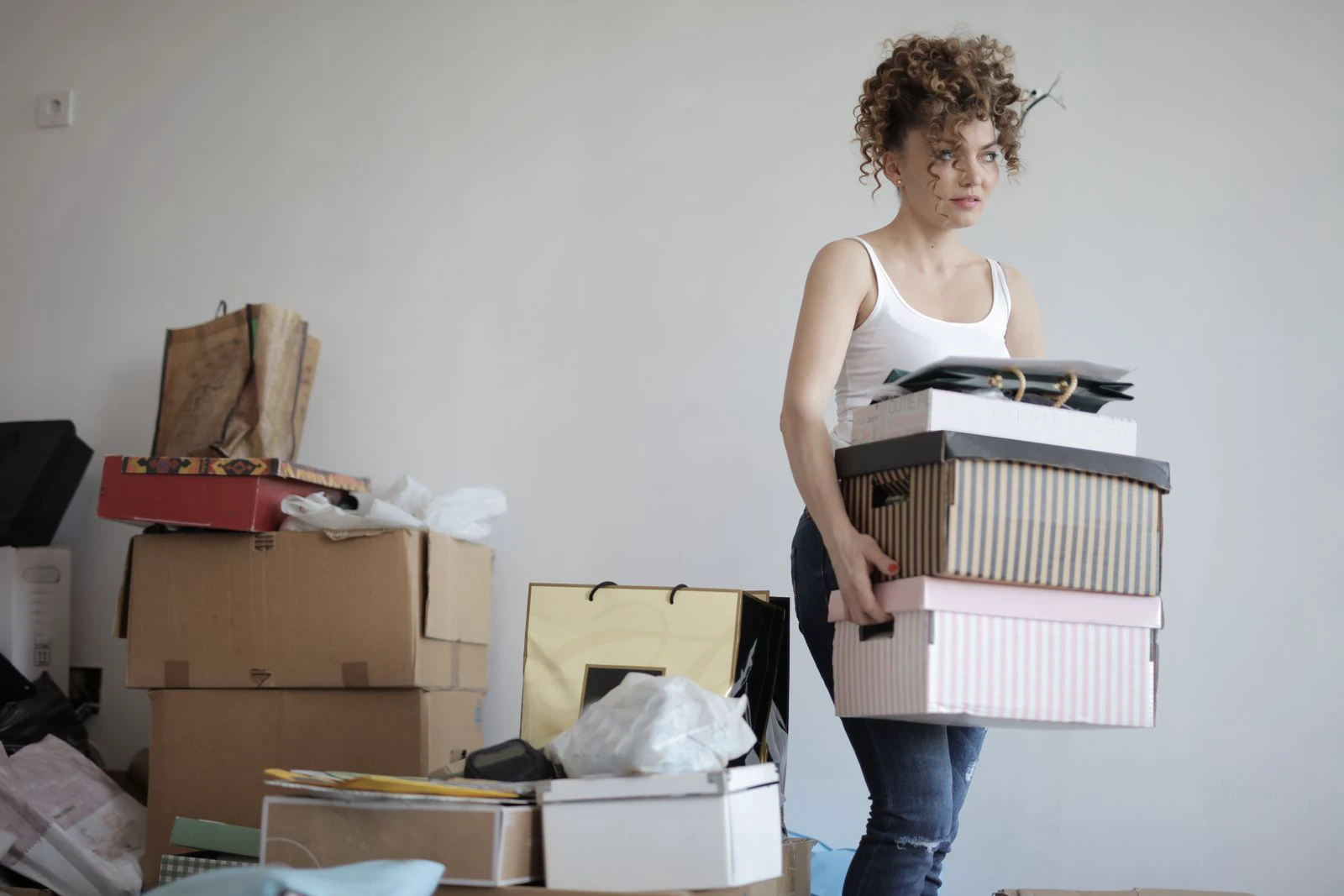 A person carrying stacked boxes while packing a home for a move