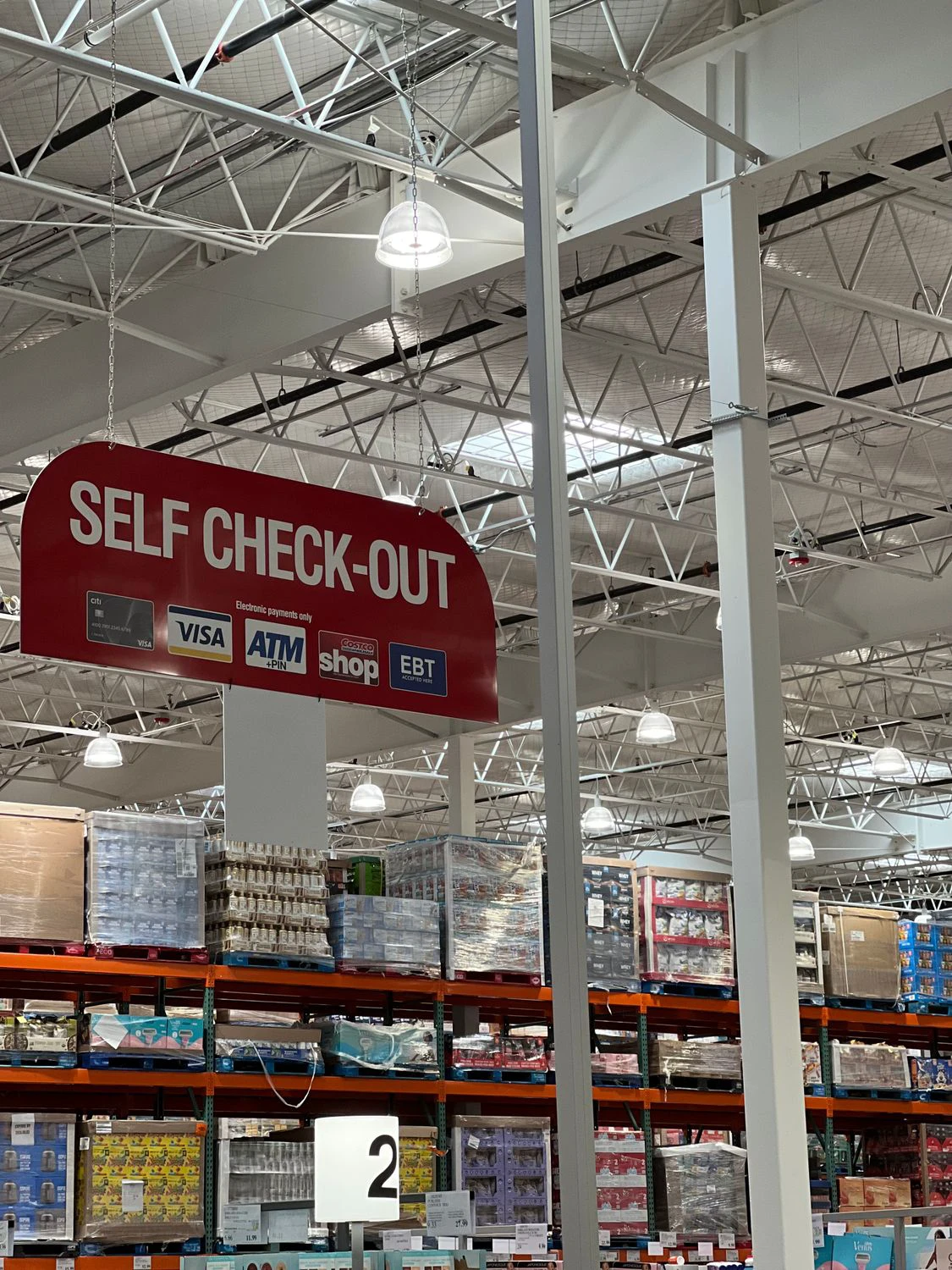 Self-checkout sign above a large store's payment area