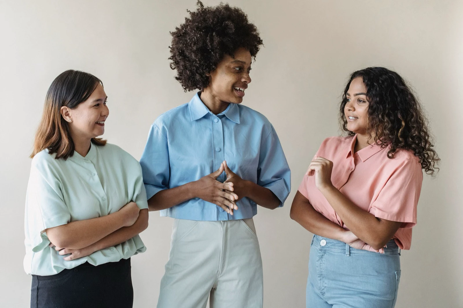 Three adults standing together in a relaxed conversation