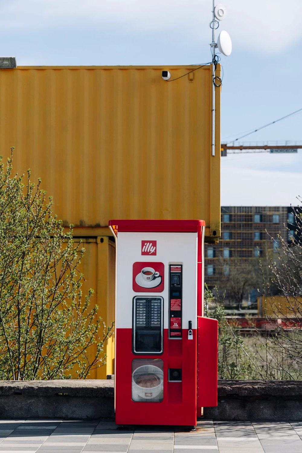 Red automatic coffee vending machine with a drink selector and payment panel