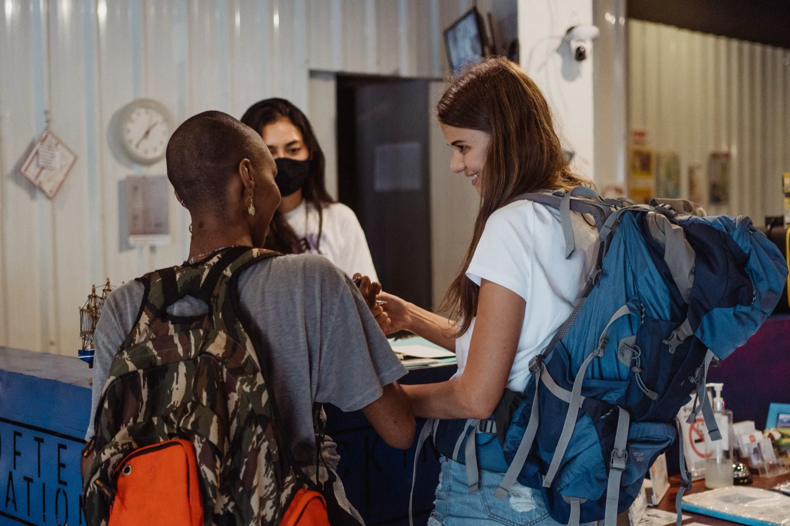 Young travelers checking in with a receptionist at an accommodation desk
