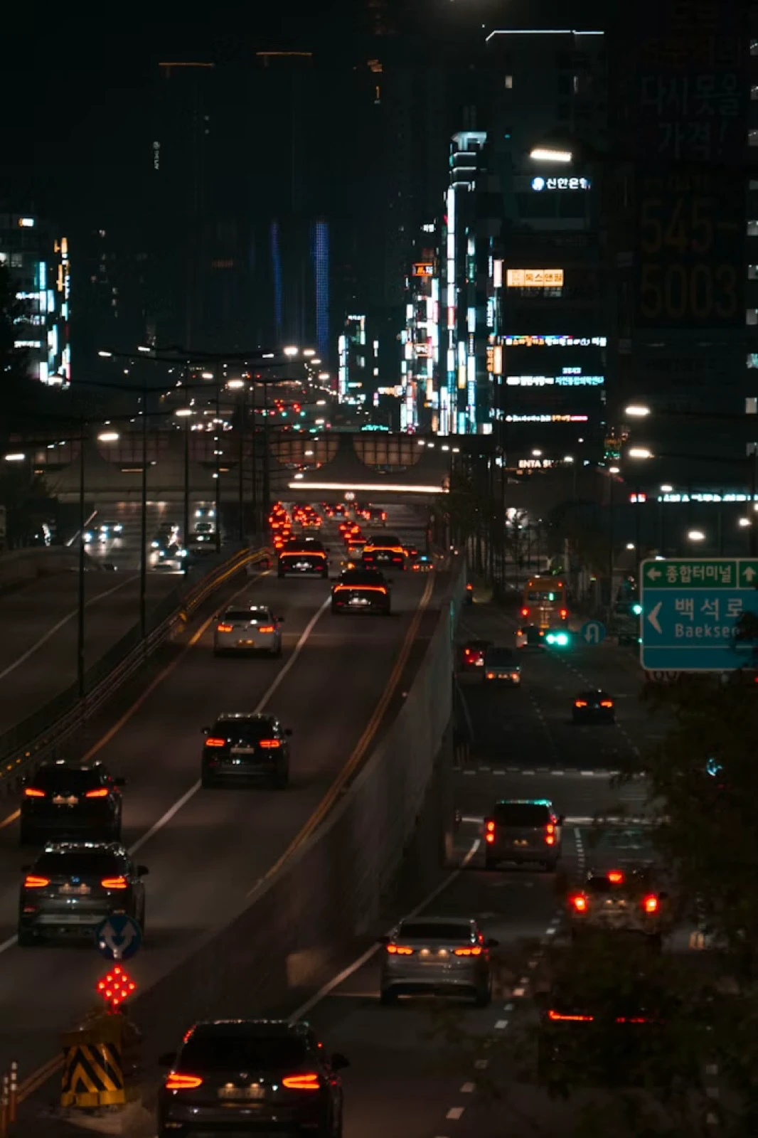 South Korean city road with Korean signs and traffic after dark