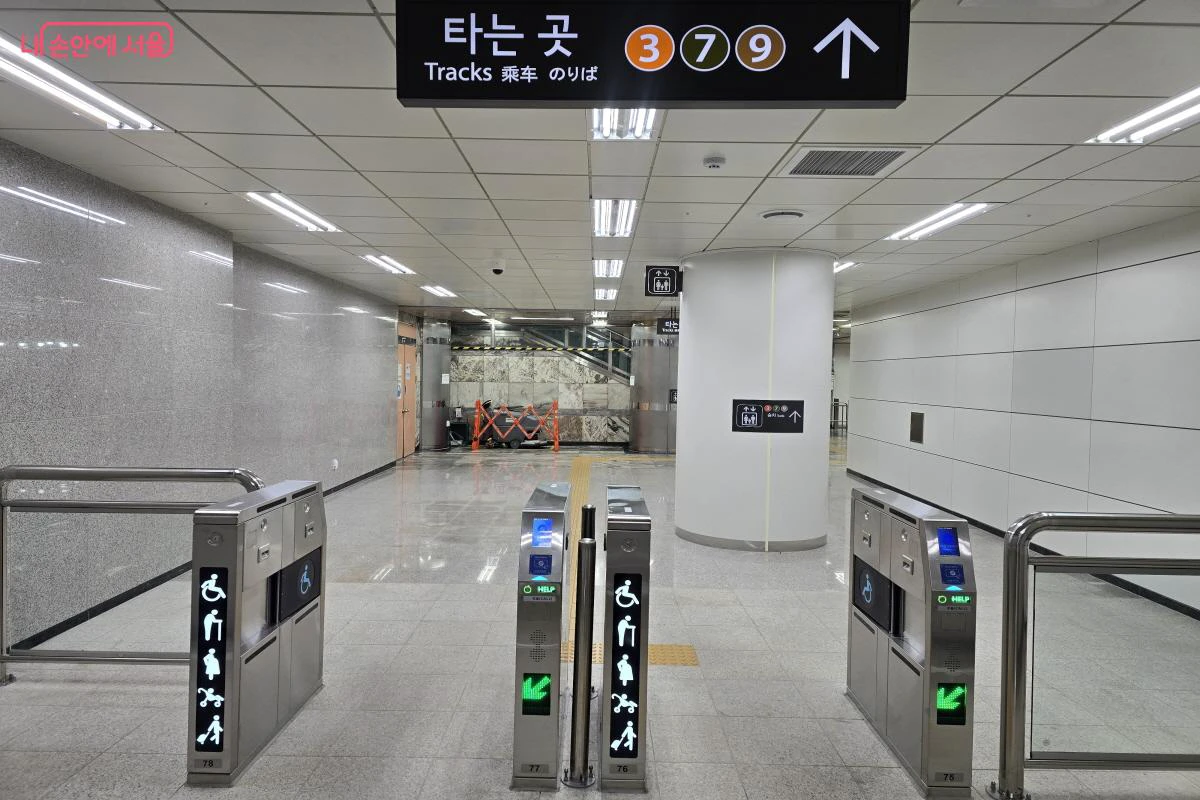 Wide accessible fare gates marked for strollers and wheelchairs in a Seoul subway station