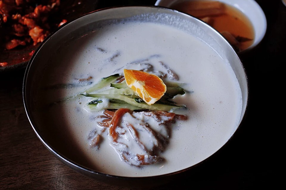 Mi kongguksu dingin dalam kuah kedelai kental dengan mentimun dan tomat