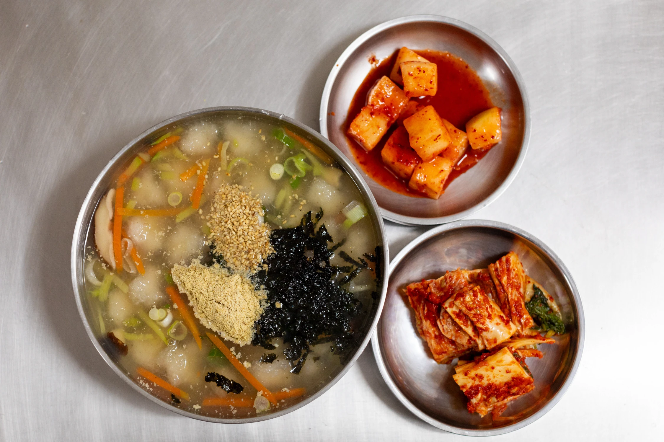 Sup pangsit kentang Gangneung dengan kimchi lobak potong dadu dan kimchi sawi putih