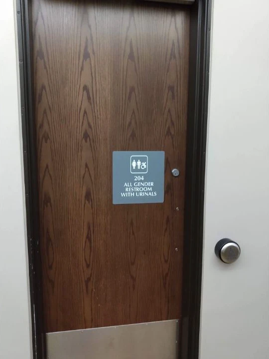 Door sign stating that an all-gender restroom contains urinals